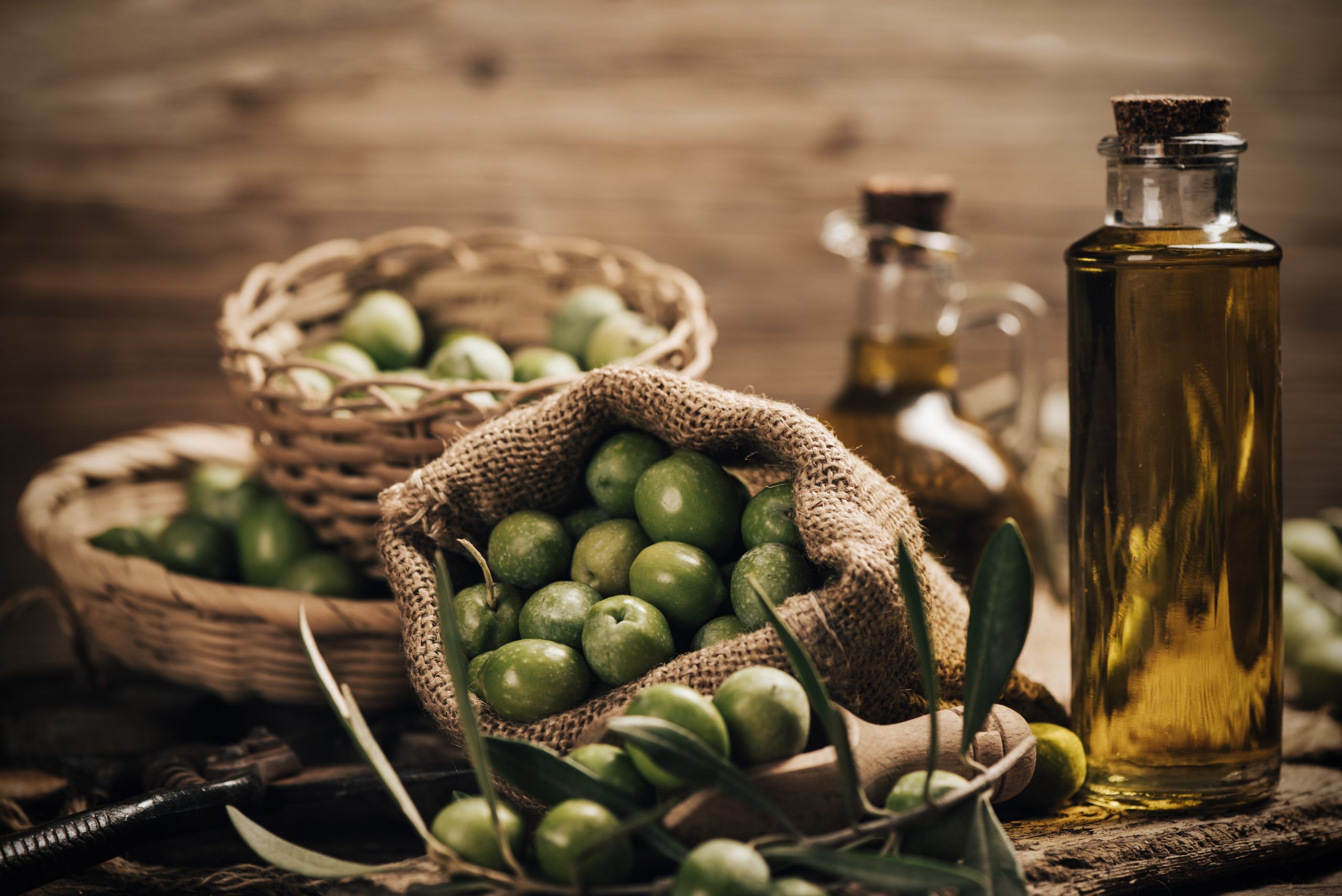 Green olives and olive oil in a bottle